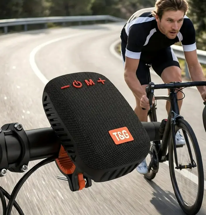 Cyclist riding a mountain road with a T&G Bluetooth speaker mounted on the handlebar